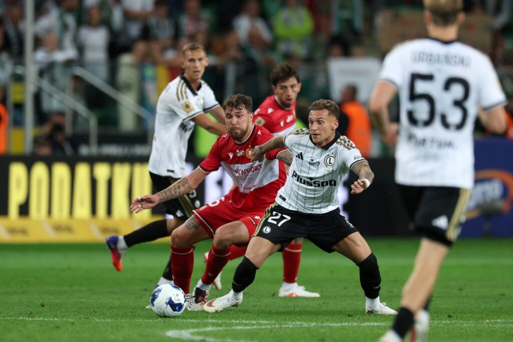 Piłkarze Widzewa Łódź i Legii Warszawa walczą o piłkę podczas meczu Ekstraklasy