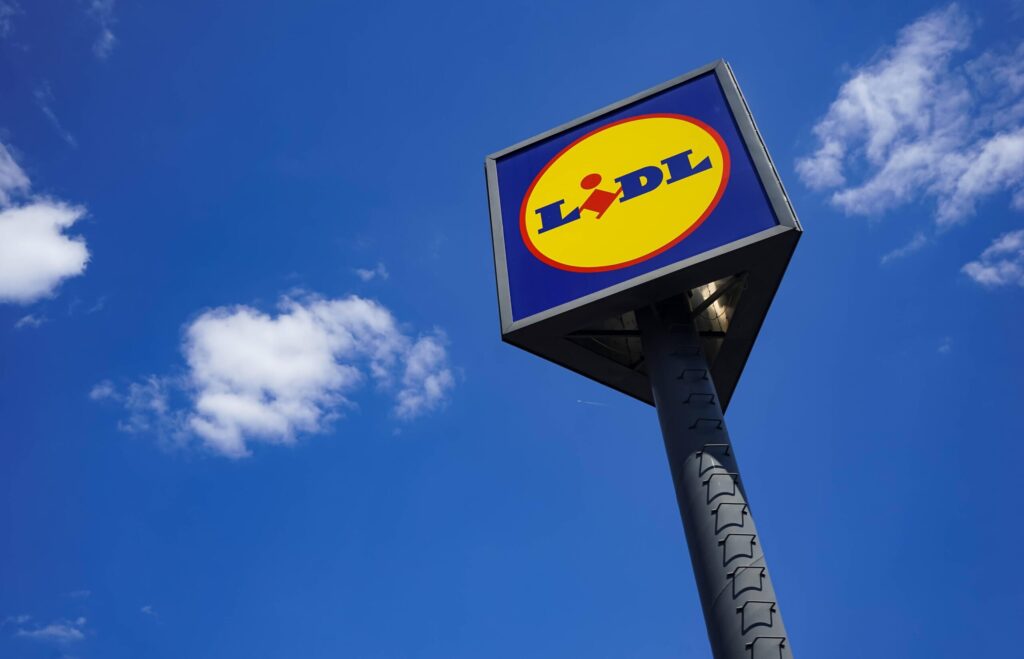Logo Lidl i PZPN na tle stadionu piłkarskiego